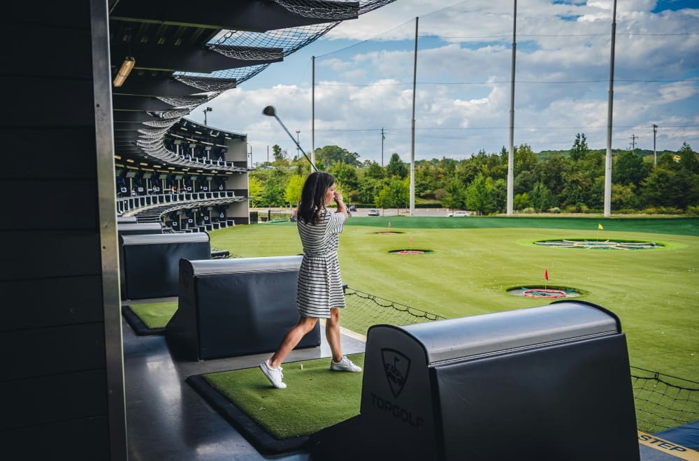 Golfeuse au practice utilisant une méthode d'apprentissage personnalisée : apprendre le golf seul avec planning et ressources organisées