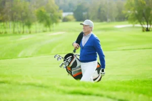 Golfeur senior marchant sur un parcours herbeux démontrant qu'arthrose et golf sont compatibles