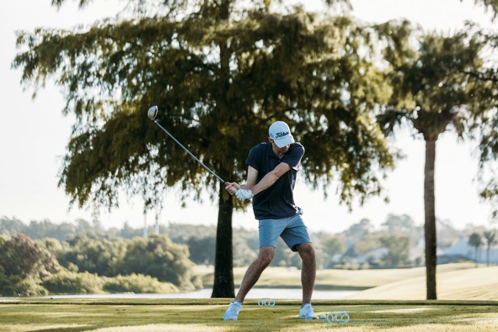 Golfeur en plein swing optimisant sa stratégie golf au driver