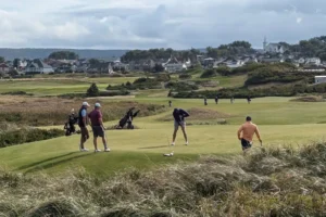 Équipe de golfeurs souriants en compétition de scramble golf sur un parcours verdoyant