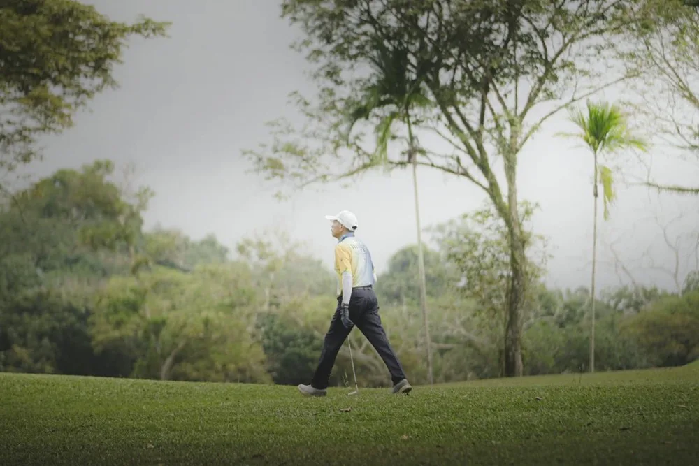 Golfeur senior marchant seul sur un fairway, illustration de la marche et de la distance au golf après 70 ans